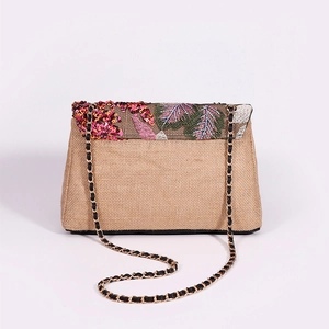 Straw shoulder bag with floral embroidery, sequins and gold chain strap on white background