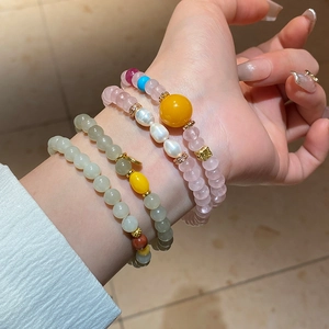 Détail de quatre bracelets de perles avec jade Hetian et accents d'ambre empilés