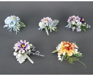 Detail showing five assorted artificial floral boutonnieres for weddings and business events