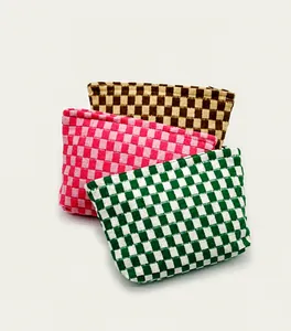Three knitted checkered makeup bags in green, pink and tan colors stacked together