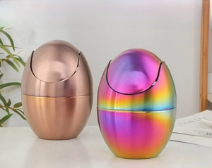 Detail of rose gold and rainbow egg-shaped mini desktop trash cans with flip lids