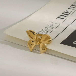 Macro detail of a 3D butterfly gold titanium steel ring on a vintage newspaper background