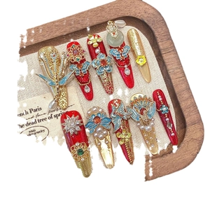 Luxurious handmade press-on nails in red and gold with 3D floral and rhinestone details