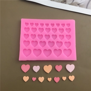 Pink silicone heart mold for baking and chocolate with finished colorful heart shapes