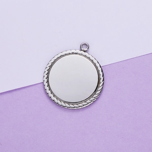 Close-up of a silver stainless steel round pendant with detailed rope edge and mirror finish