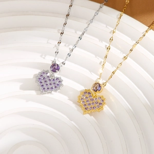 Detailed macro view of heart pendant necklaces with purple zircon in gold and silver