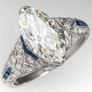 Macro view of marquise-cut marquise ring with sapphire accents and milgrain detailing