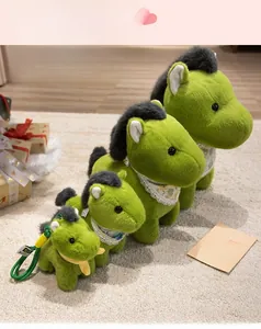 Set of four green horse plush toys in various sizes with lace scarves on a carpet