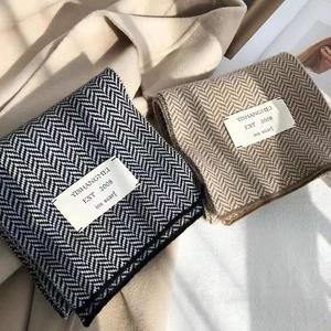Détail d'écharpes en maille à chevrons marron et noir avec une texture douce et épaisse