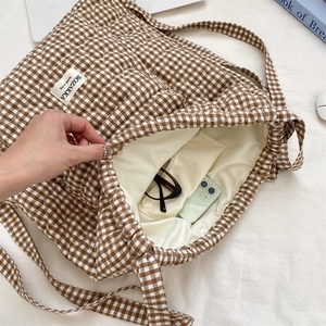 Macro detail showing quilted pattern and spacious interior with phone for size reference