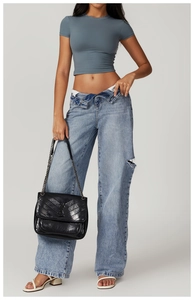 Detailed view of grey-blue slim fit cropped yoga top with high-waisted distressed denim jeans