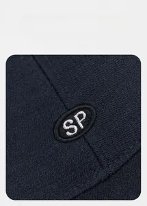 Close-up of SP logo embroidery on navy blue cotton twill baseball cap fabric