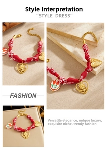Detail of red floral fabric rope and gold plated heart pendants on a vintage style bracelet
