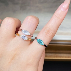 Three elegant marquise cut moissanite rings in silver and gold finishes on a hand