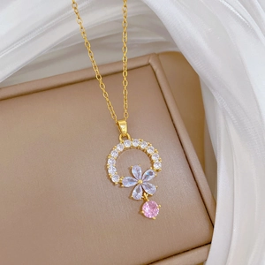 Detail of flower pendant with pink and white zircon crystals on a gold chain necklace