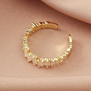 Minimalist adjustable golden cuff ring with baguette zircon stones in silk setting