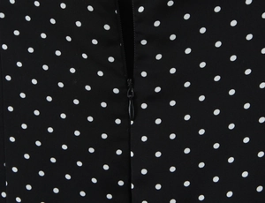 Macro detail of polka dot print fabric with a black invisible zipper closure