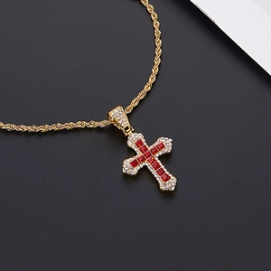 Détail du collier croix dorée avec zircons rouges carrés et micro-pavé de pierres blanches
