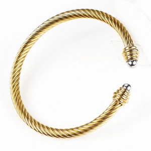 Macro detail of twisted cable texture and dual-tone gold and silver finish on open cuff bracelet