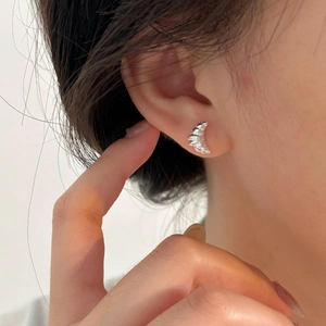 Primo piano di orecchini a lobo a forma di croissant in argento sterling 925 indossati