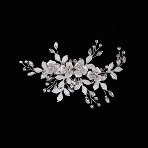 Silver bridal hair clip with rhinestone floral and leaf design on black background