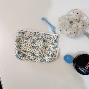 Close-up of floral cotton pouch with blue zipper pull for lipstick storage