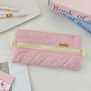 Close-up of pink quilted pencil case with soft fabric texture and zipper detail