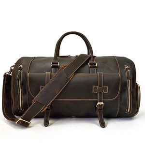 Detail view of vintage leather travel bag with white stitching and side zipper pockets