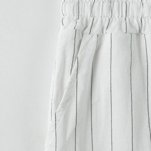 Dettaglio dei pantaloni da spiaggia in lino da uomo con vita elastica e righe verticali