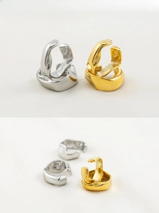 Detailed view of irregular lava style ear cuffs in polished gold and silver finishes