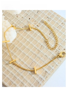Close-up of 18K gold minimalist bracelet featuring sleek bar accents and lobster clasp