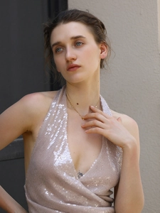 Gros plan d'un mannequin portant un collier doré à billes avec pendentif disque brillant