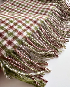 Detailed macro view of soft cashmere-like brown and green plaid scarf with fringe texture