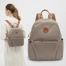 Close-up and on-model view of taupe nylon backpack with brown leather accents