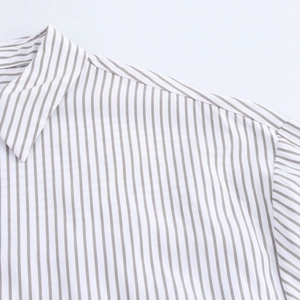 Détail du col à revers classique et de la couture d'épaule sur une chemise à rayures grises
