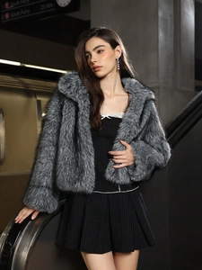 Manteau en fausse fourrure grise pour femme avec col rabattu dans un décor urbain chic