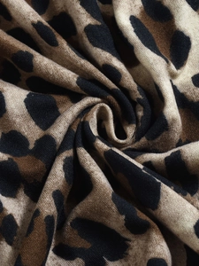 Gros plan sur un tissu en maille douce à imprimé léopard montrant la texture fine