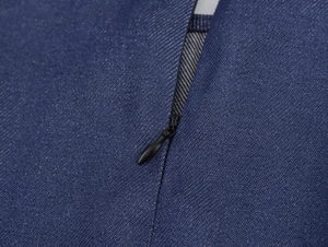Détail de la fermeture éclair invisible noire sur robe en denim bleu foncé texturée