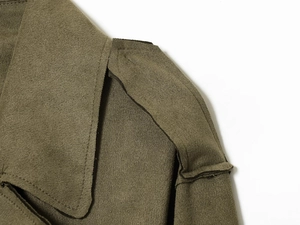 Detalle de gabardina verde militar mostrando las charreteras y la textura de la costura