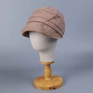 Close-up of brown short brim cotton cap featuring layered pleat texture and retro design