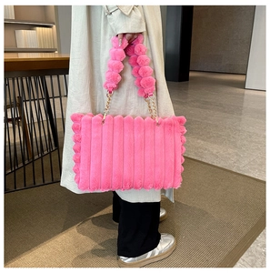 Detail of pink plush tote bag showing vertical quilted texture and gold chain strap