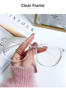 Close-up of stylish transparent large frame glasses held over a lifestyle magazine
