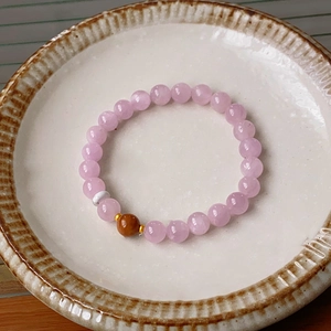 Detailed shot of Kunzite and Kuka beaded bracelet on a vintage ceramic plate