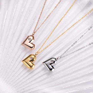 Détail de colliers en acier titane avec pendentifs cœur en or rose, or et argent poli