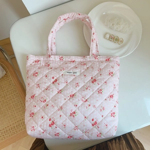 Close-up of pink floral quilted cotton handbag with simple wish tag and props