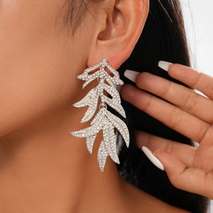 Vue détaillée des boucles d'oreilles feuilles en cristal argenté portées par un mannequin