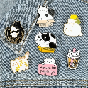 Lot de sept jolis pins et broches en émail chat sur une veste en jean bleu clair