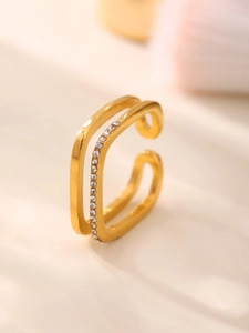 Macro detail of a gold-plated double-layer ring featuring pavé set white cubic zirconia