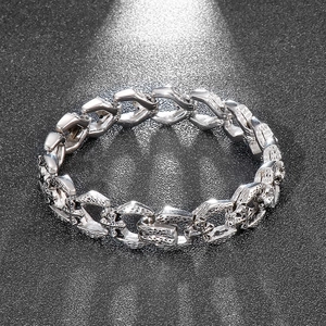 Macro view of silver punk cuban chain bracelet featuring detailed cross relief patterns