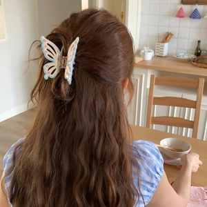 Blue butterfly hair claw clip with pink dots styled on long curly brunette hair